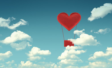 Fototapeta premium Fabric red heart air balloon on blue sky background