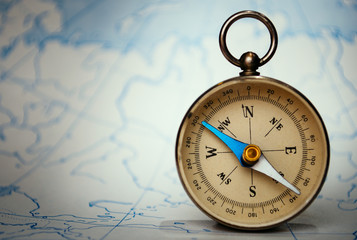 Magnetic compass standing upright on a map