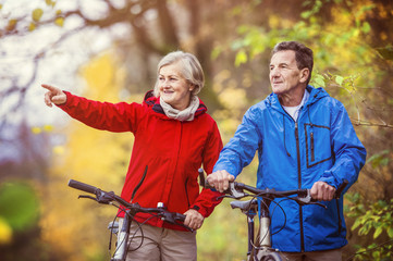 Active seniors walking with bike