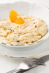 oatmeal with dried fruits and orange in white bowl