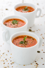 fresh tomatoe soup in cups with seeds and parsley