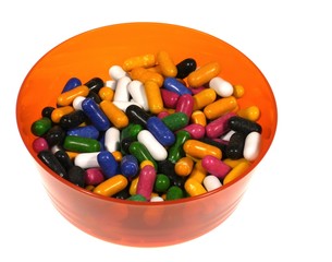 Many colorful sugar candies in an orange bowl