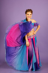 Beautiful belly dancer wearing a purple costume