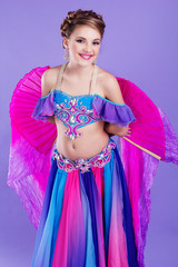 Beautiful belly dancer wearing a purple costume