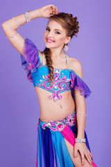 Beautiful belly dancer wearing a purple costume