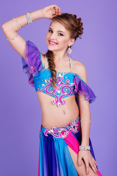Beautiful belly dancer wearing a purple costume