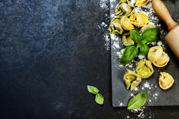 Homemade raw Italian tortellini and basil leaves - obrazy, fototapety, plakaty