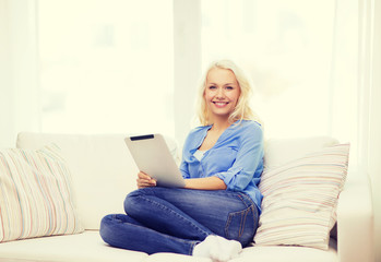 smiling woman with tablet pc computer at home