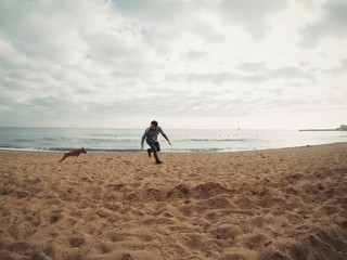 Man runs with his dog on beach