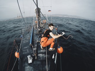 Sailor unties the rope on board