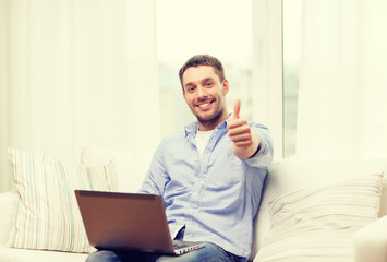 smiling man working with laptop at home