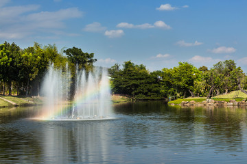 Fountain with rainbow in the artificial pond.