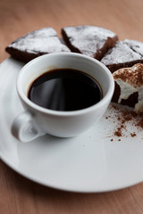 Obraz na płótnie Canvas Closeup of a cup of black coffee with chocolate cake