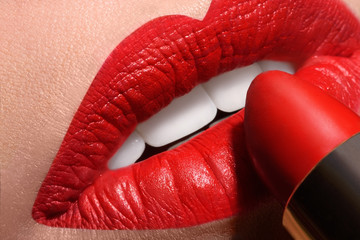 Fototapeta premium Sensual open mouth with red tube of lipstick