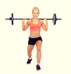 Fototapeta na wymiar smiling sporty woman exercising with barbell