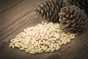 clean pine nuts on wooden table with pine cones