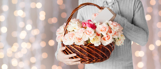 man holding basket full of flowers and postcard