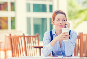 Woman talking on mobile phone outside corporate office building