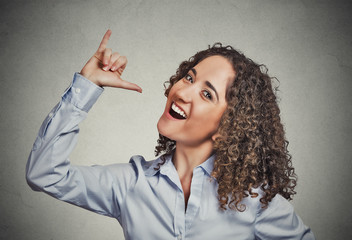 Woman showing let's drink hand gesture grey wall background 