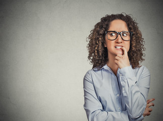 woman with glasses biting her fingernails craving for something