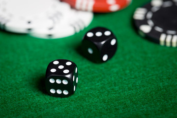 close up of black dices on green casino table