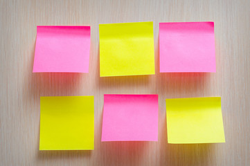 bright yellow and pink stickers on a wooden background