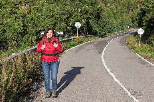 Girl on the highway with a backpack going camping. By Portugal.