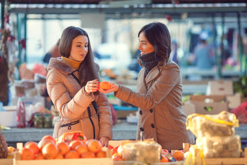 Young woman buying organic fruit on the market