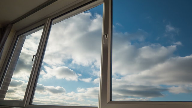 Clouds seen through large, domestic windows.