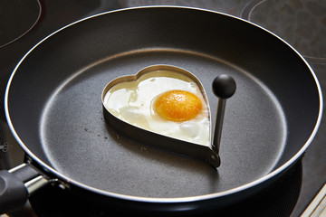 Preparing fried eggs in heart form