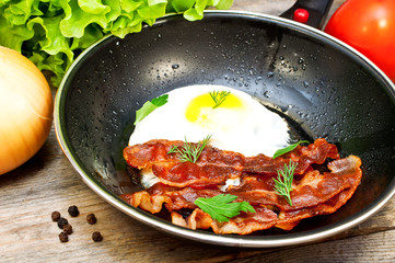 bacon and eggs in a frying pan