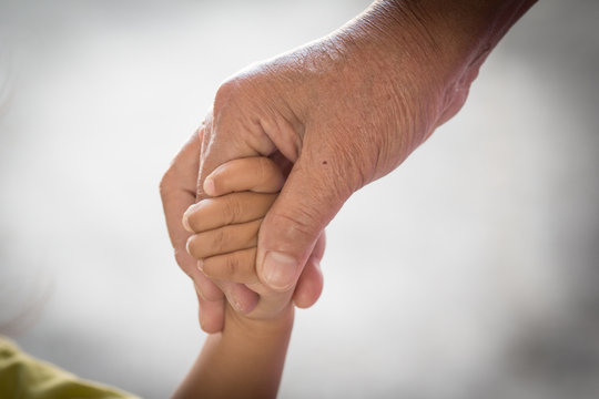 Old woman and kid holding hand together