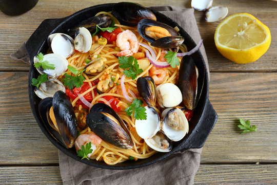 Tasty pasta with mussels, squid, parsley and lemon