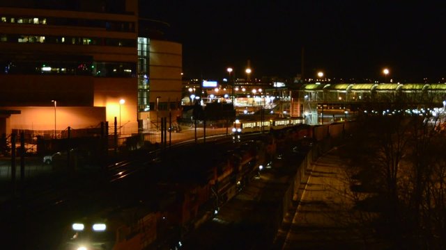 A commuter and a freight train cross paths at night
