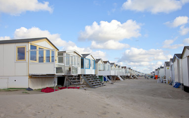 Fototapeta na wymiar Beach houses on beach in a row with blue sky