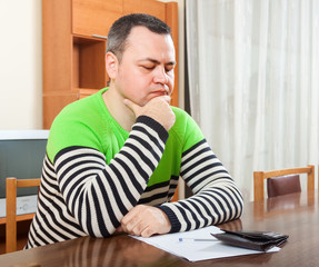 Fototapeta premium sad man filling financial documents