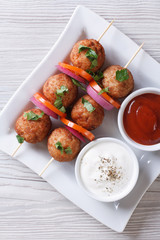 meatballs on skewers and sauces vertical top view