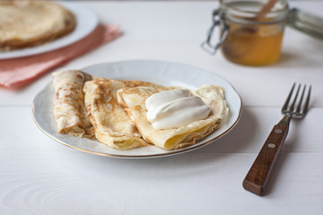 breakfast with pancakes, honey and sour cream
