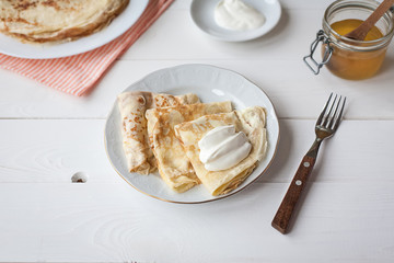 breakfast with pancakes, honey and sour cream