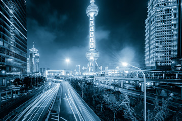 Naklejka premium the light trails on the modern building background in shanghai c