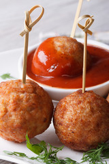 Grilled meatballs nd tomato sauce on a white plate  vertical