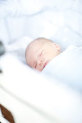 Adorable newborn baby sleeping on back with delicate smile