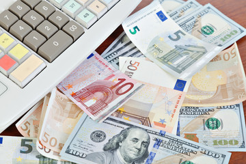 Cash register and different paper currencies foreground