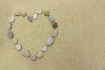 Fototapeta na wymiar Beach stones in the shape of a heart on a sandy beach