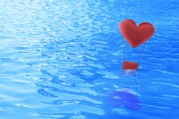 Fabric red heart air balloon float on sea