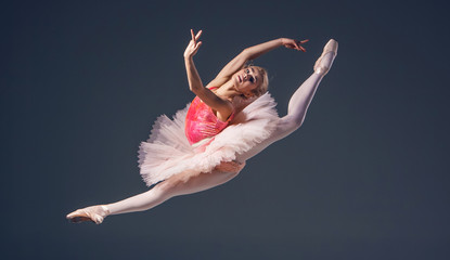 Beautiful female ballet dancer on a grey background. Ballerina