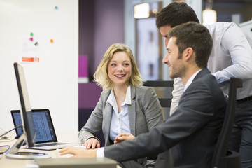 Group of business people in a meeting at office, working on comp