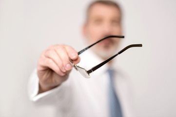 Close-up of male hand holding eyeglasses
