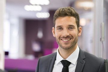 Portrait of smiling Businessman posing  in modern office