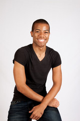 Black man in black shirt smiling at the camera